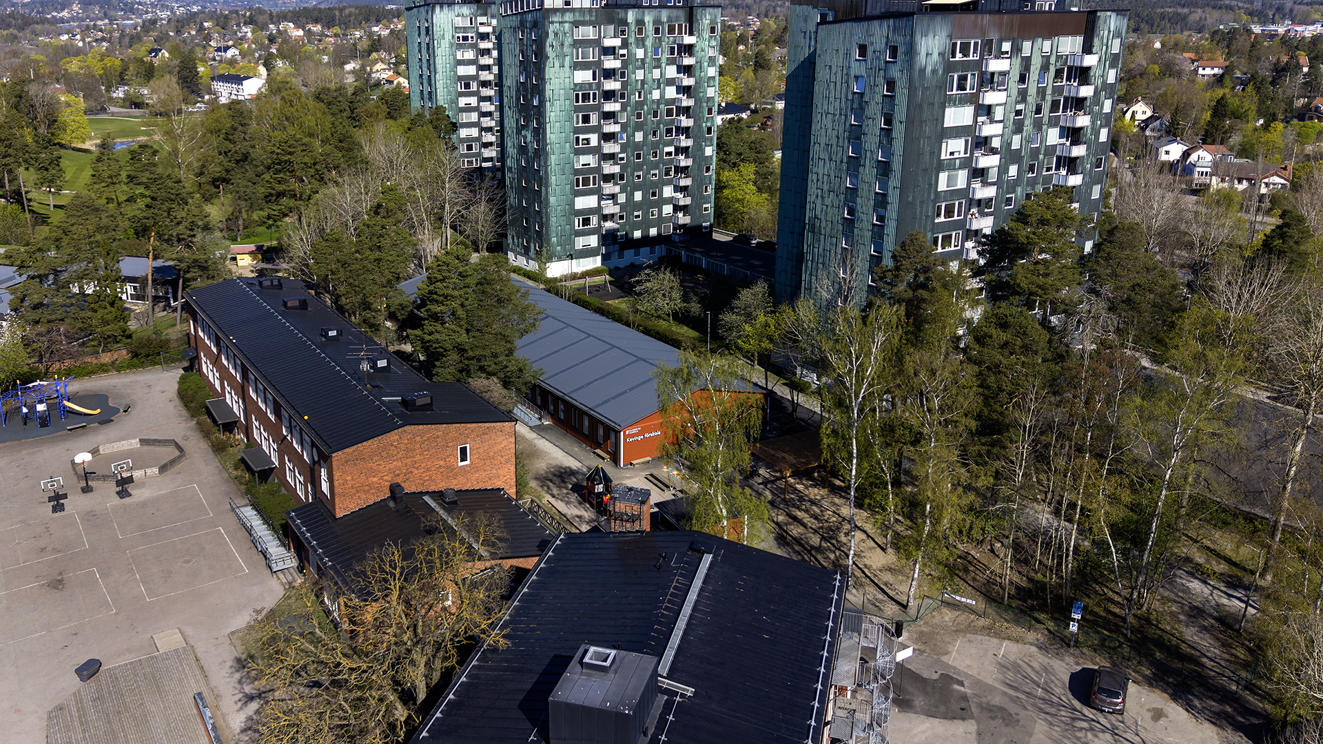 Drönarbild över Kevinge förskola i Danderyd, falurös modulbyggnad i blandad stads- och villabebyggelse