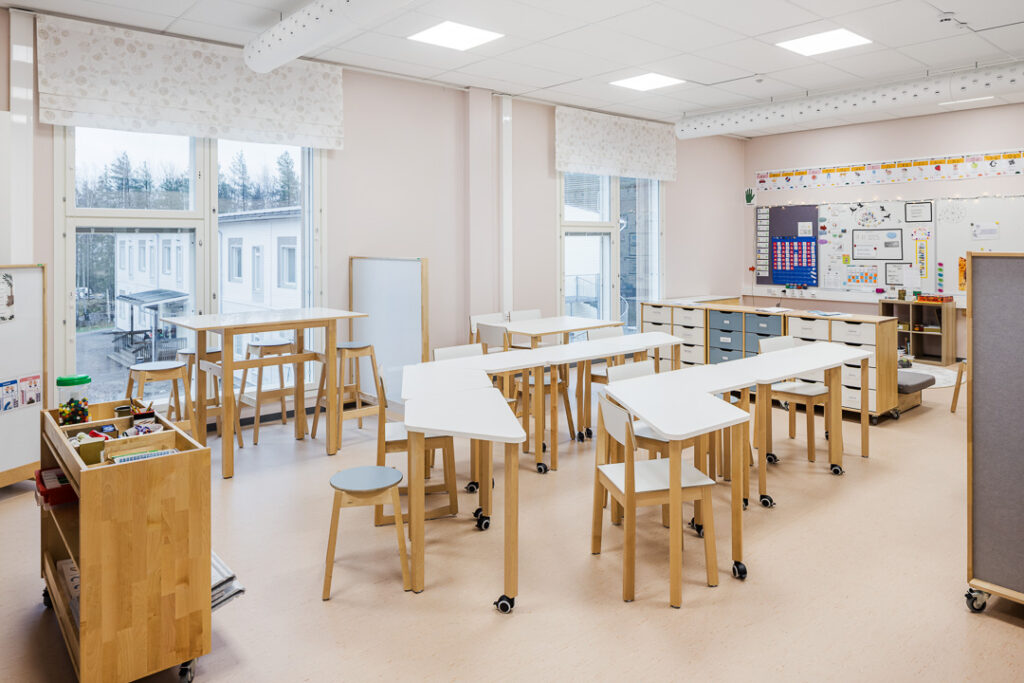 Ljus undervisningslokal med bord och stolar i Kaikumetsä skola.