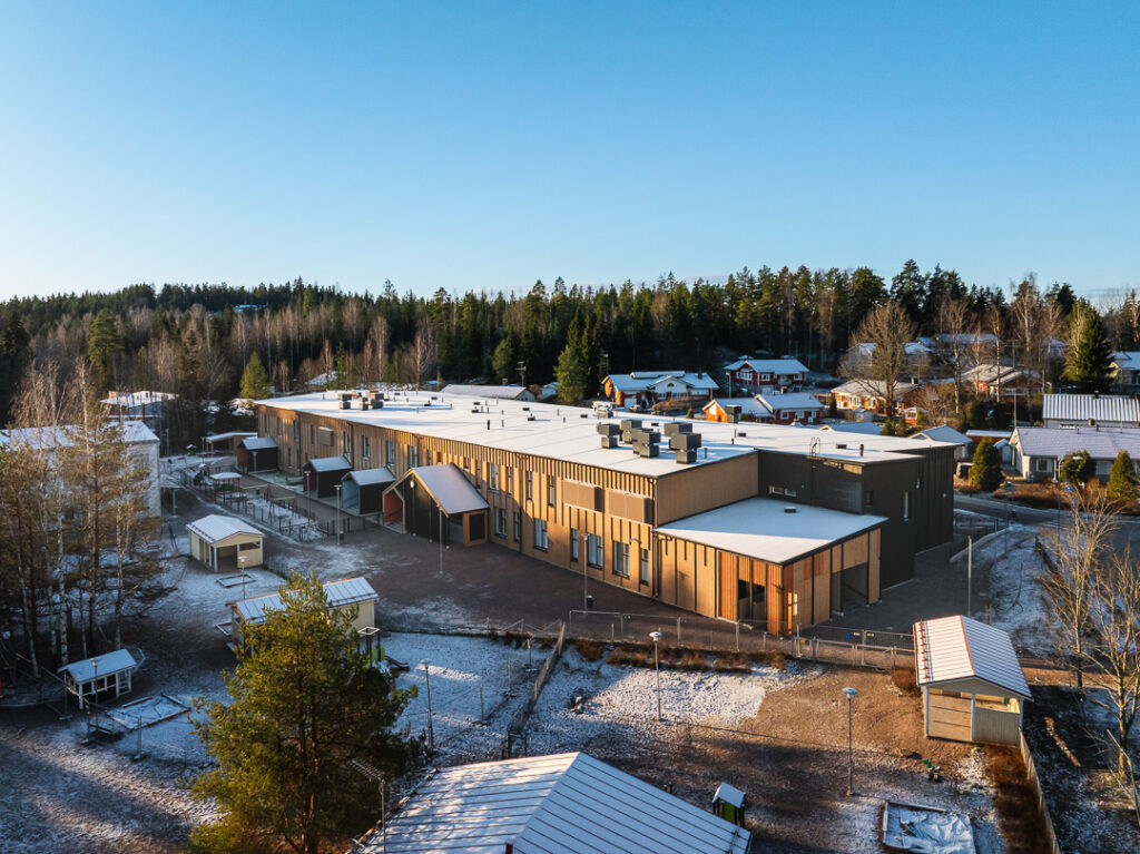 Flygbild över Kaikumetsä skola och förskola med omgivande skog.