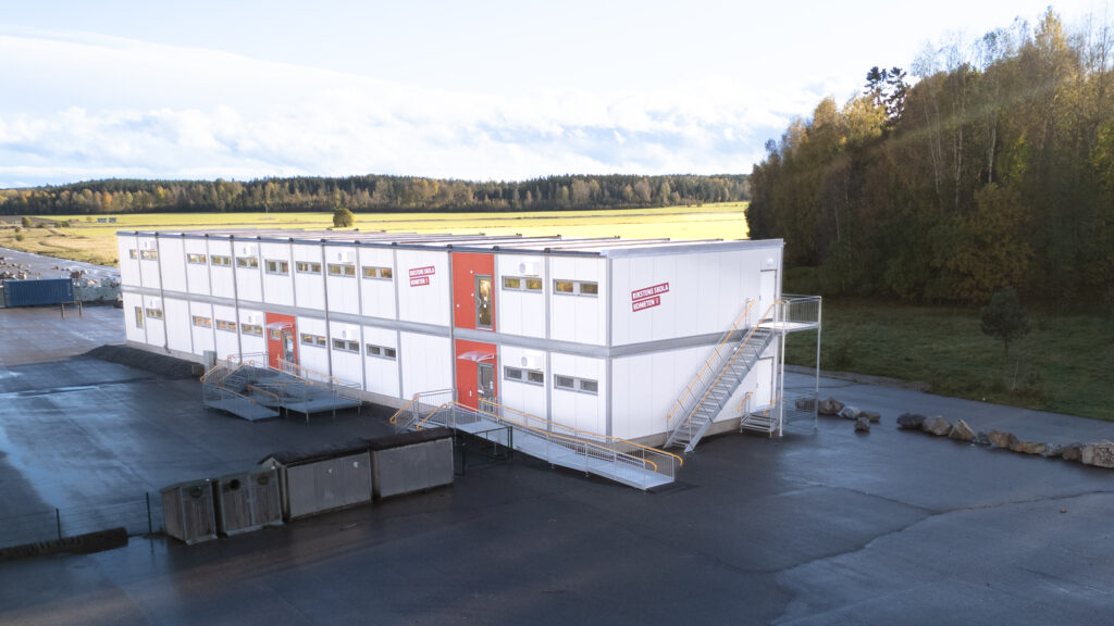 Rikstens skola Kometen i Tullinge med ljus fasad och röd entrédörr.