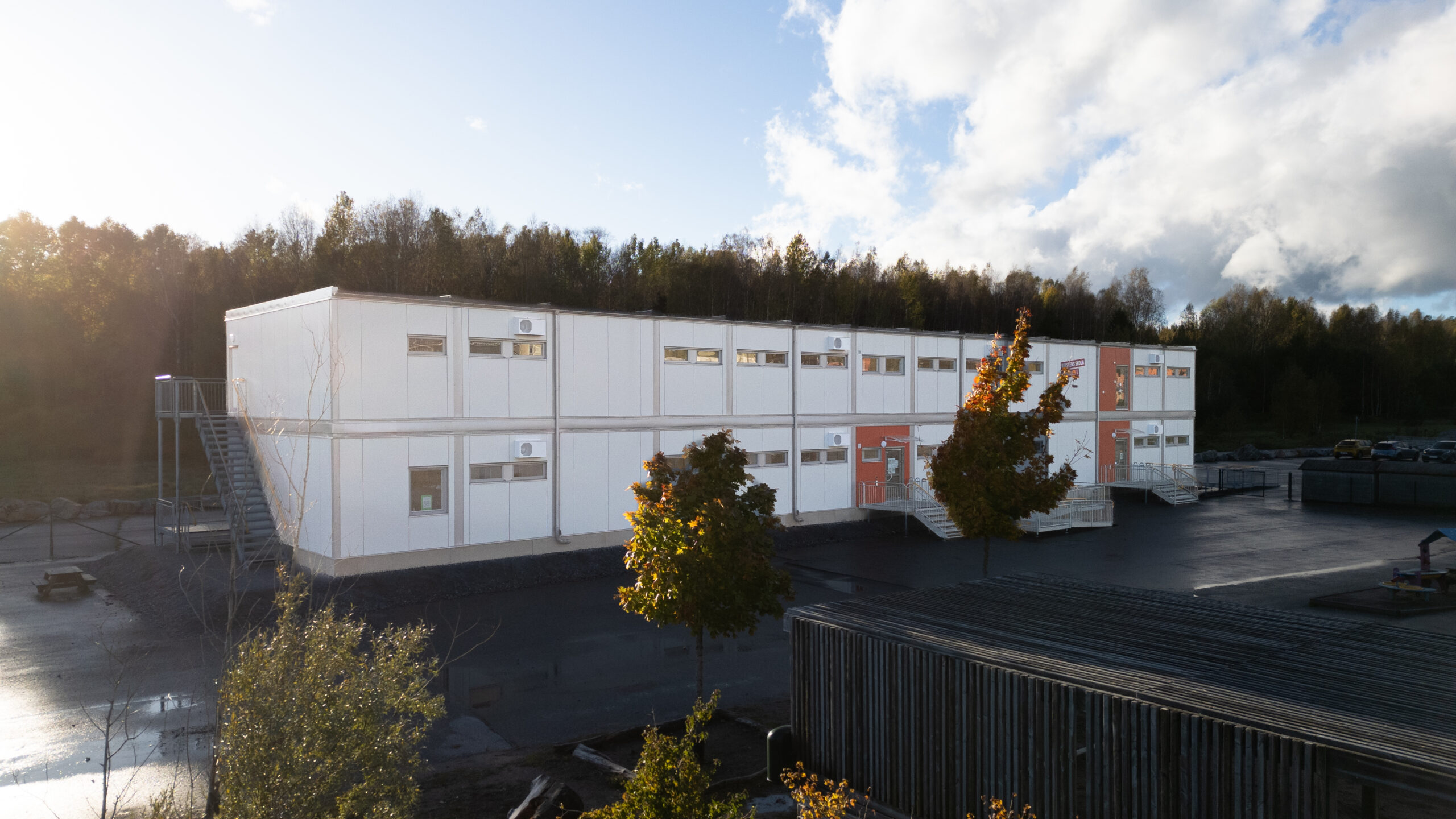 Rikstens skola Kometen i Tullinge med träd och utemiljö framför byggnaden.