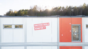 Fasaddetalj med skylt för Rikstens skola Kometen i Tullinge.